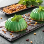 Green gelatin dessert for weight loss served on black slate with mint leaves and honey drizzle.